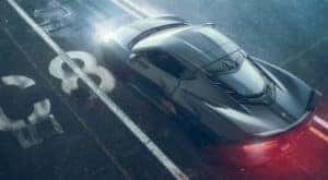 A grey 2022 Chevy Corvette is shown from a high angle driving past a white 'C8' marking on pavement.
