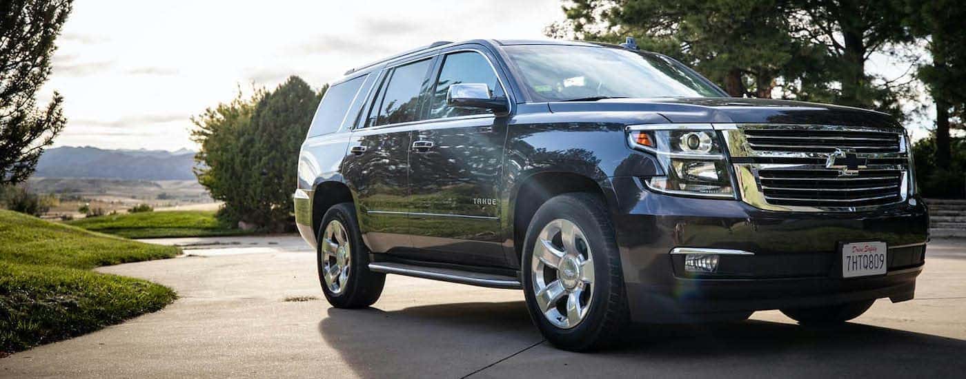 A dark blue 2016 Chevy Tahoe Premium is shown parked in a driveway.