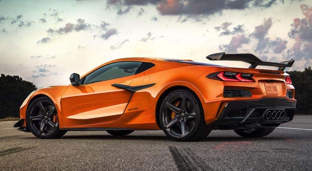 An orange 2023 Chevy Corvette Z06 is shown from the rear at an angle while parked after leaving a Chevy dealer.