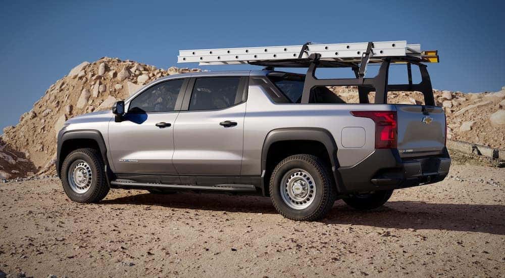A silver 2024 Chevy Silverado EV is shown from the side while loaded with ladders.