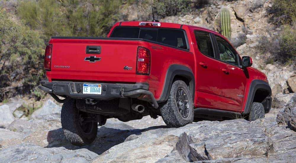 Rear view of a red 2022 Chevy Colorado ZR2 Bison driving over rocky terrain