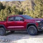 A red 2023 Chevy Colorado ZR2 is shown from the side on a dirt road.