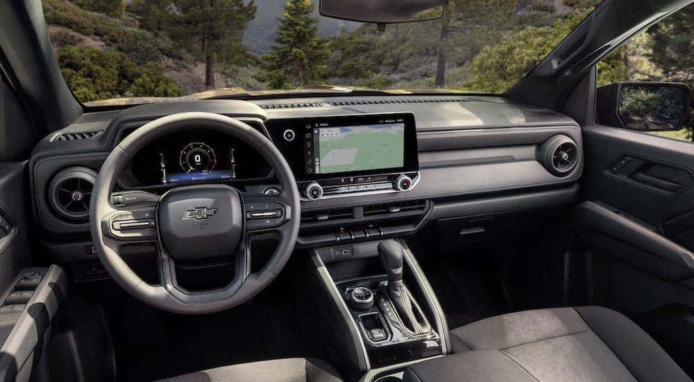 The black interior of a 2023 Chevy Colorado Trail Boss is shown from the driver's seat after leaving a dealer that has a Chevy Colorado for sale.