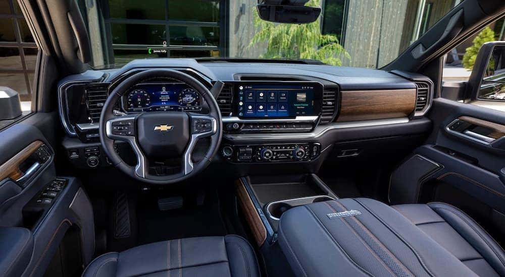 The black interior of a 2024 Chevy Silverado 2500 HD High Country is shown from the drivers seat.