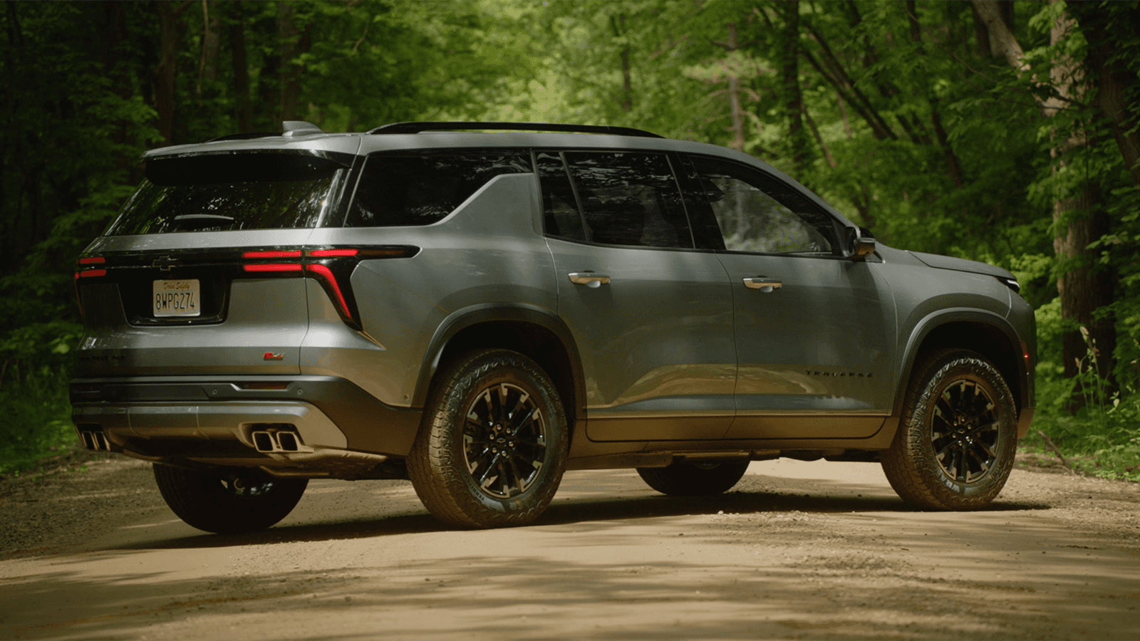 A grey Chevrolet Traverse parked on the road in a forest