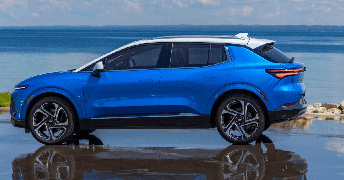 A blue Chevrolet Equinox with a white roof parked on a beach