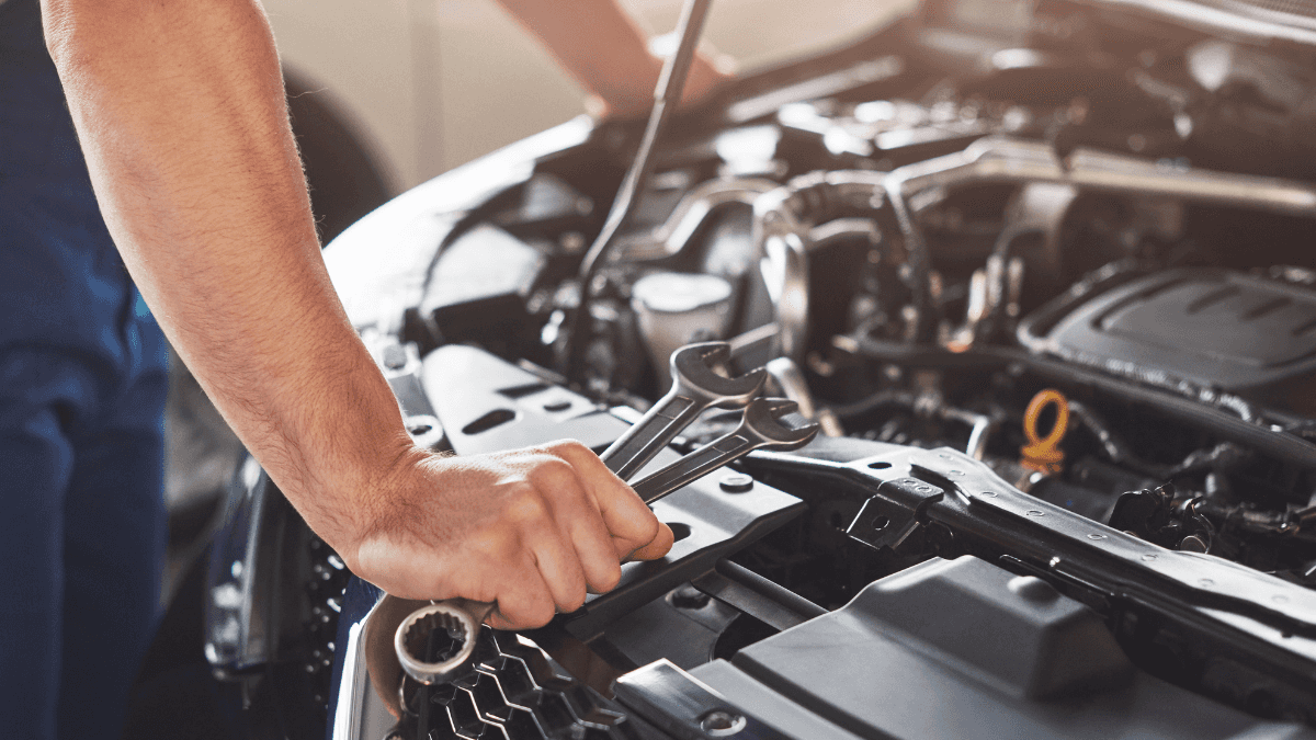 A man performing engine maintenance on a vehicle