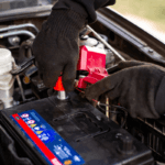 A mechanic replacing a vehicle's battery