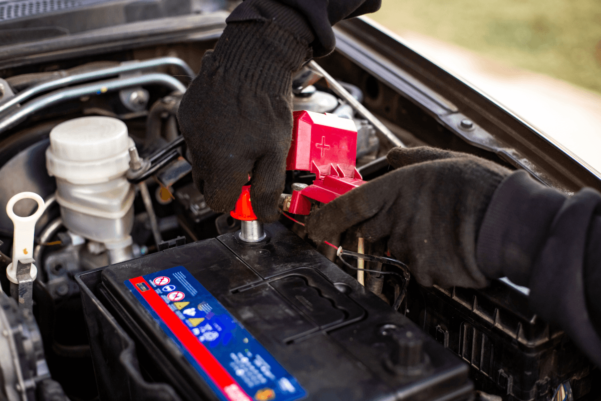 A mechanic replacing a vehicle's battery