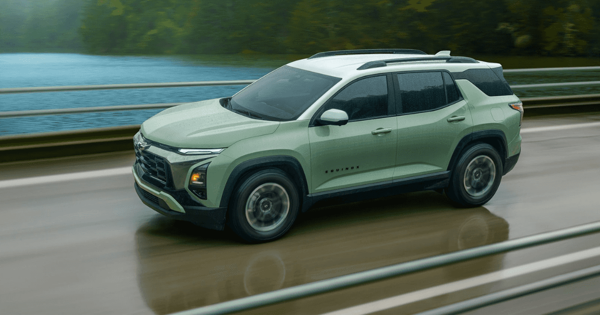 A green Chevy Equinox driving over a bridge across a river