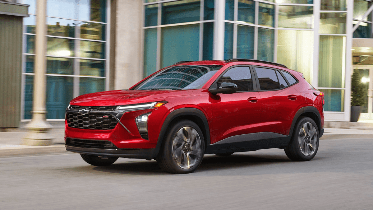 A red Chevy Trax driving by a building
