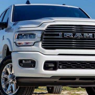 Front view of a white 2020 Ram 2500 parked in front of a brown fence