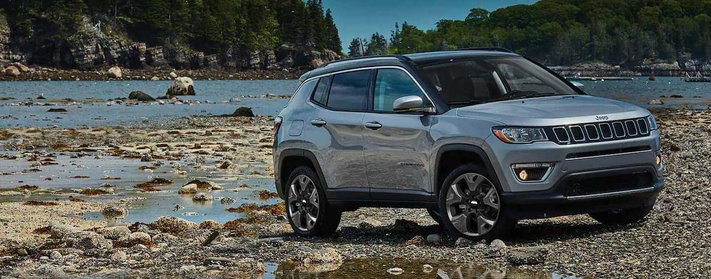 A grey 2021 Jeep Compass is shown parked next to a river after leaving a Jeep dealer in Williston.