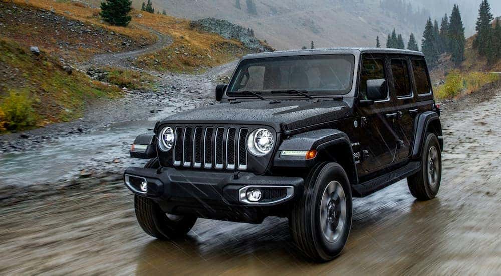 A black 2018 Jeep Wrangler is shown from the front at an angle after leaving a used Jeep dealer.