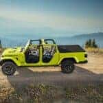 A fluorescent green 2023 Jeep Gladiator Rubicon is shown driving on a dirt road after visiting a Jeep dealer near Minot.