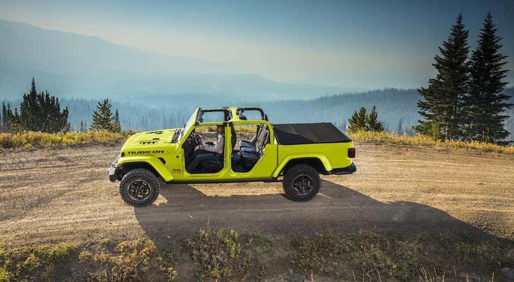 A fluorescent green 2023 Jeep Gladiator Rubicon is shown driving on a dirt road after visiting a Jeep dealer near Minot.