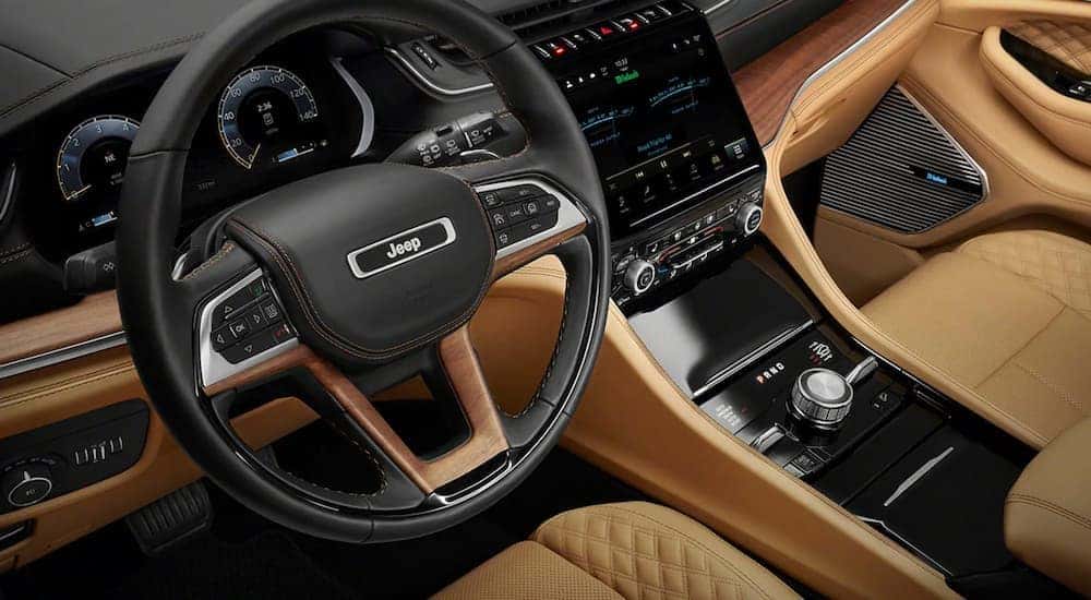 A close up of the tan and black interior of a 2023 Jeep Grand Cherokee is shown at a Jeep dealer near Minot.