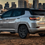 Rear and side view of the 2024 Jeep Compass with a city backdrop