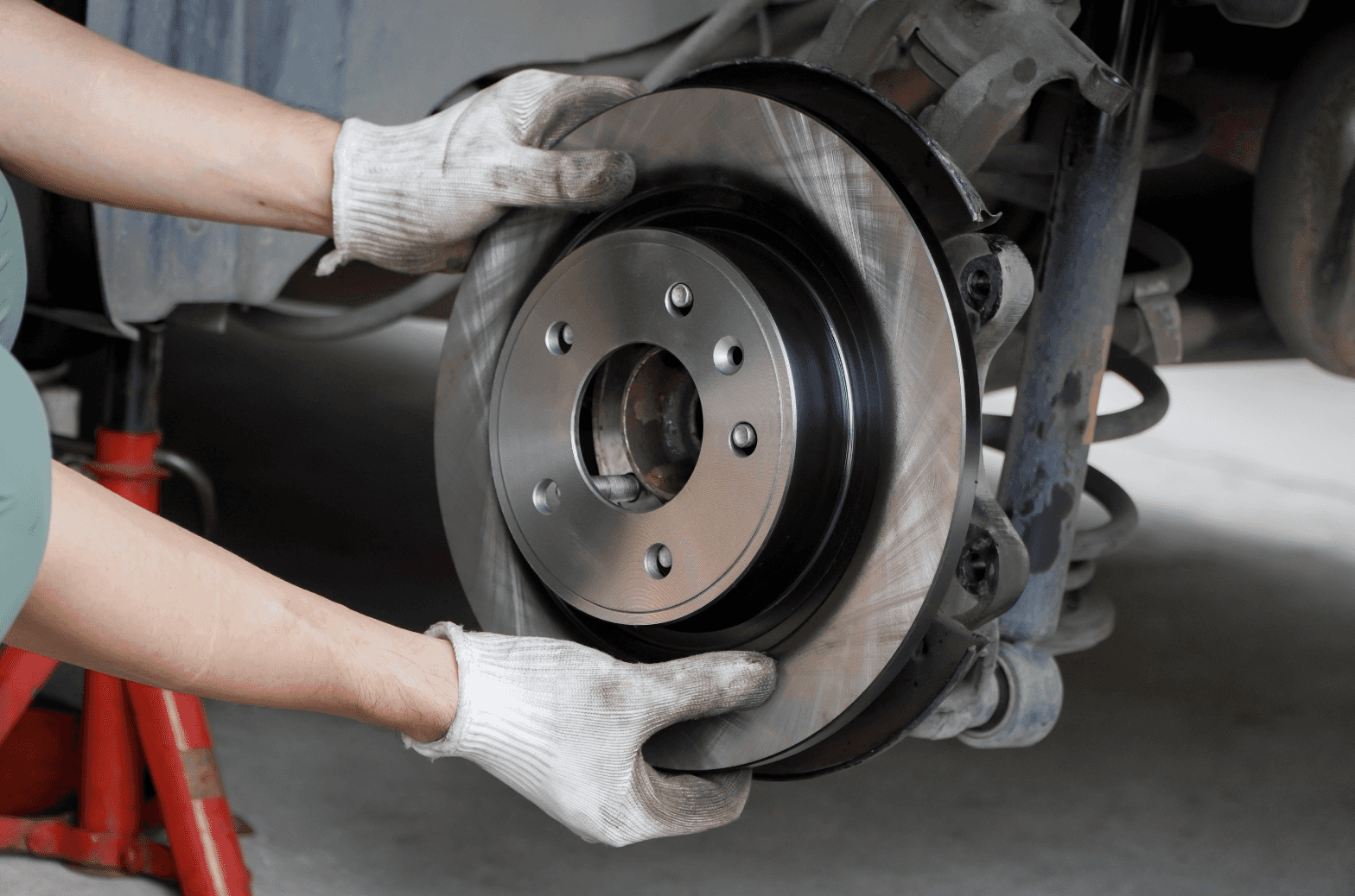 A service technician holding the brake discs of a vehicle