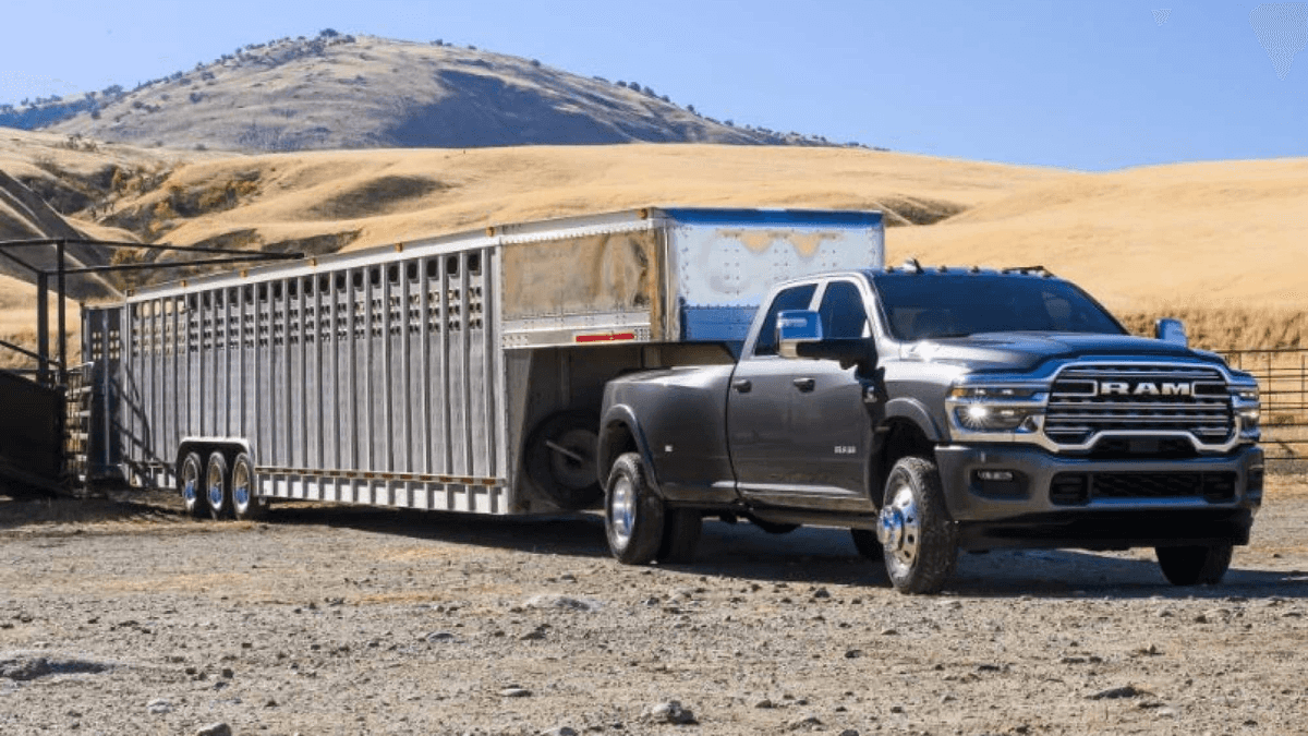 A gray 2025 RAM 3500 towing a long trailer