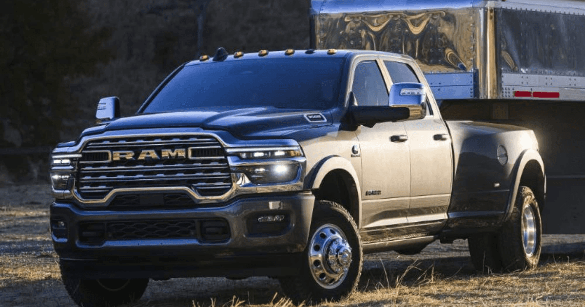 A grey RAM 3500 hauling a trailer through a field