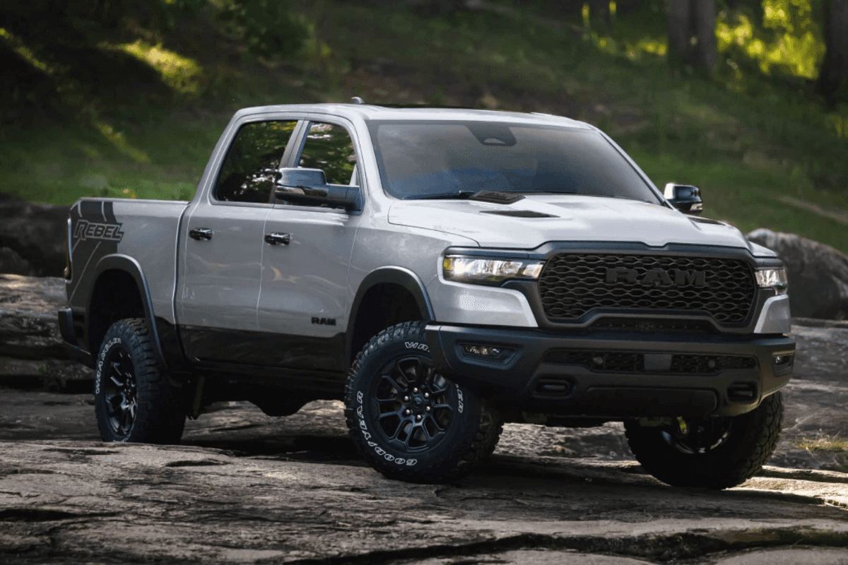 A silver RAM 1500 driving off-road on dirt