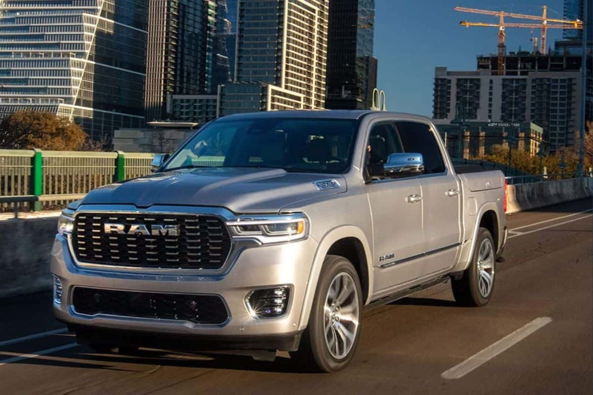 A silver RAM 1500 stopped on a bridge outside a city