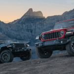 A red and blue Jeep Wrangler parked in front of a small mountain