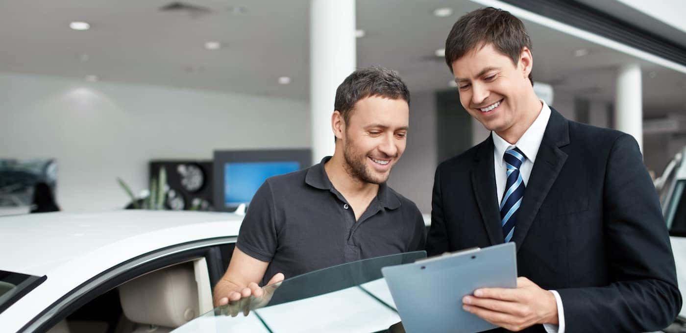 Young man with a salesman in a motor show