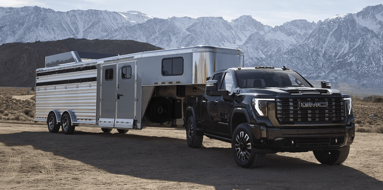 2024 GMC Sierra HD towing a trailer in a mountainous area