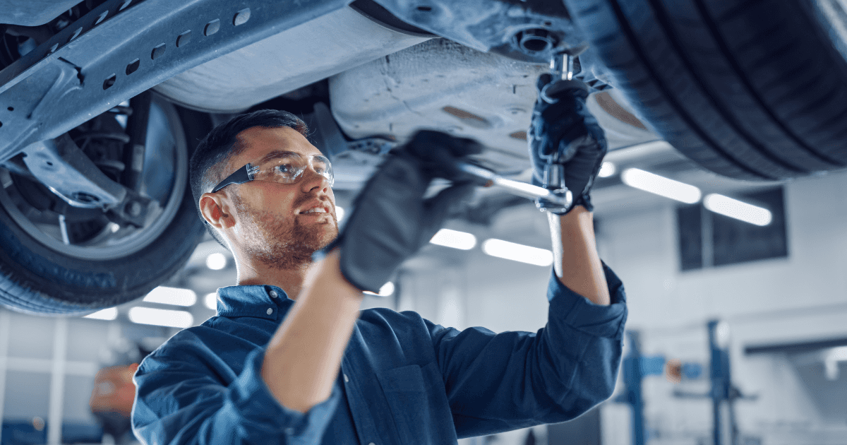 Male technician performing maintenance on a vehicle