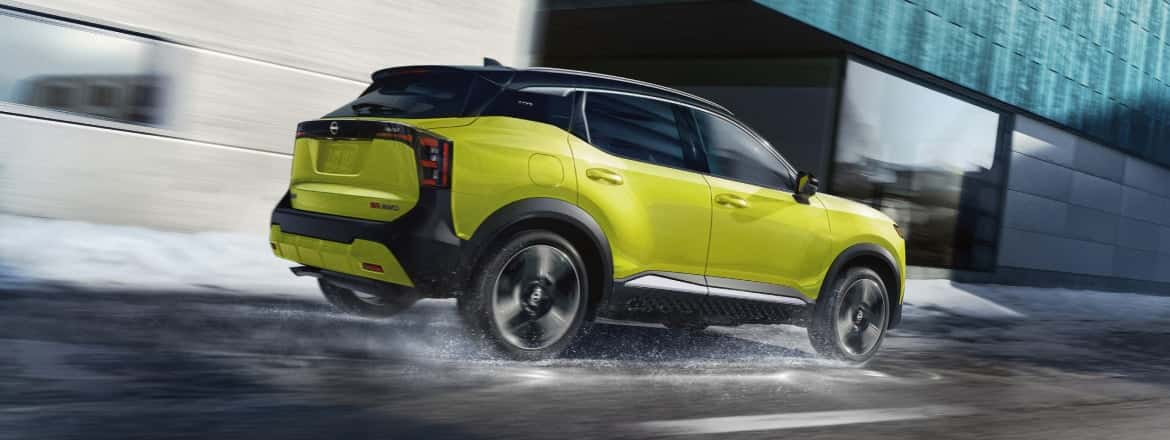 A yellow Nissan Kicks driving down a wet street