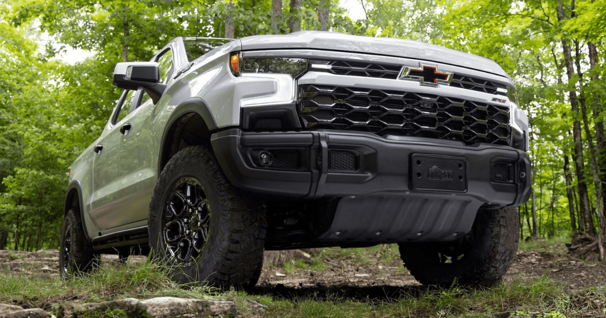 A low-angle image of a gray Chevy Silverado 1500 in a forest.