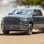 A blue RAM 1500 kicking up dust as it makes a hard turn