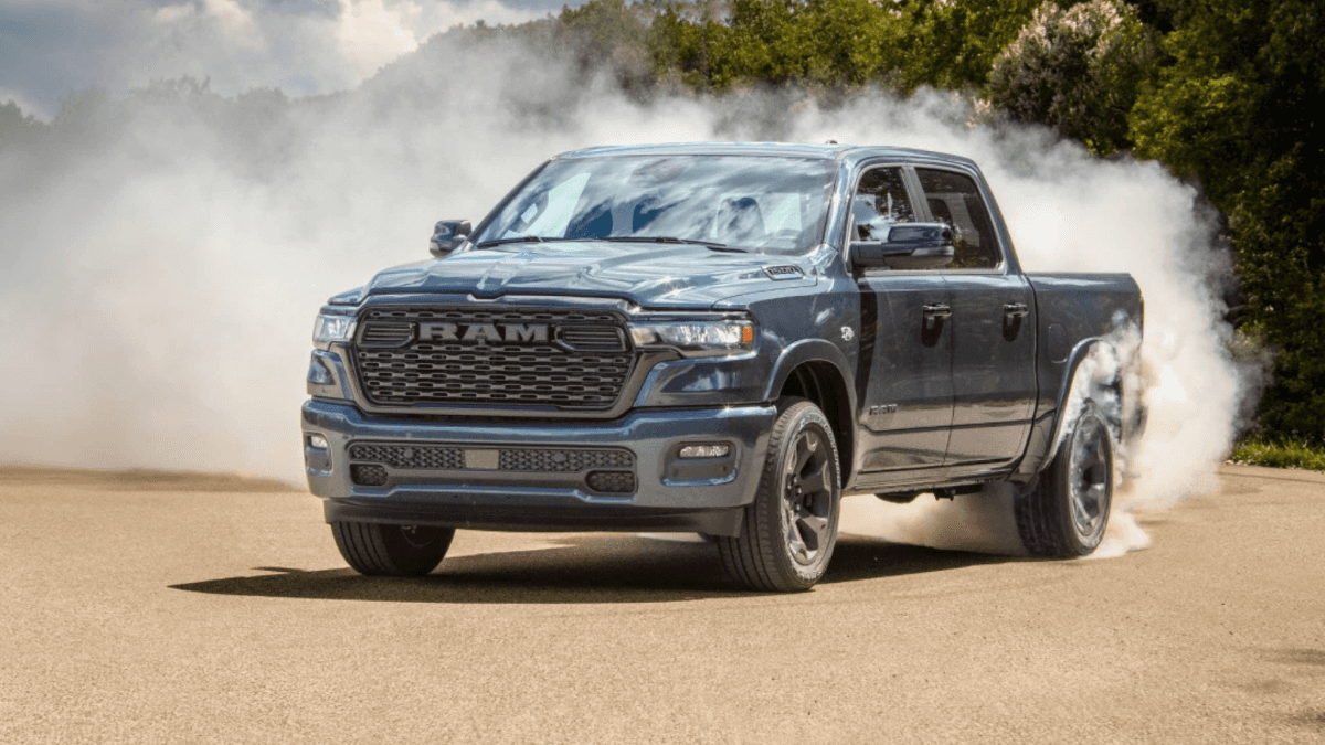 A blue RAM 1500 kicking up dust as it makes a hard turn
