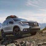 Grey 2021 Honda Passport driving up a mountain over rocks