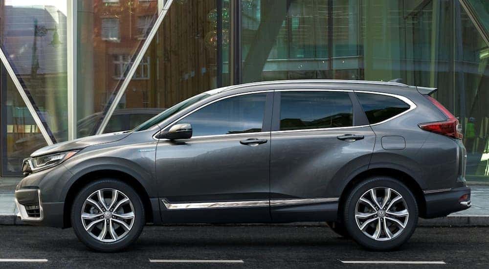 A grey Honda CR-V parked in front of a glass building