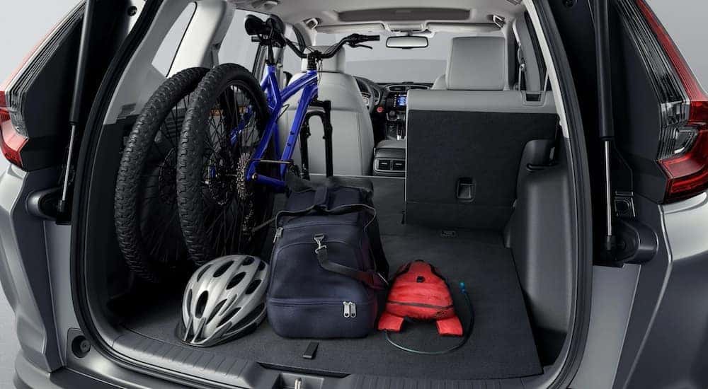A bike, helmet, duffel bag, and water bag in the trunk of a 2021 Honda CR-V
