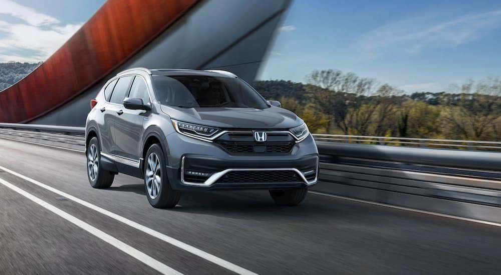 a grey 2020 Honda CR-V is shown from the front at an angle while driving down the highway.