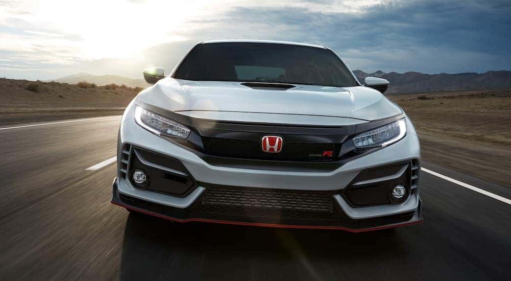 A white 2020 Honda Civic Type R is shown from the front while it drives down the road.