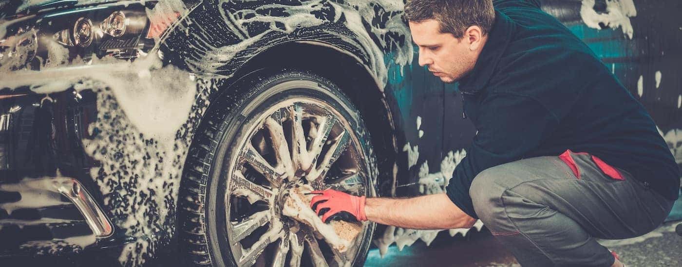 A person is shown washing a wheel before selling their car.