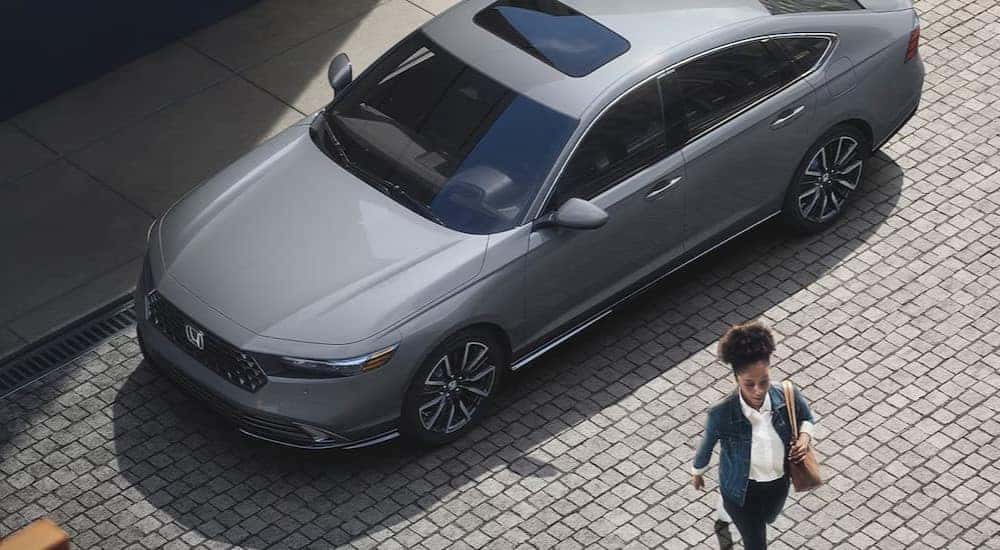 An aerial view of a gray 2023 Honda Accord Touring is shown parked on a street.