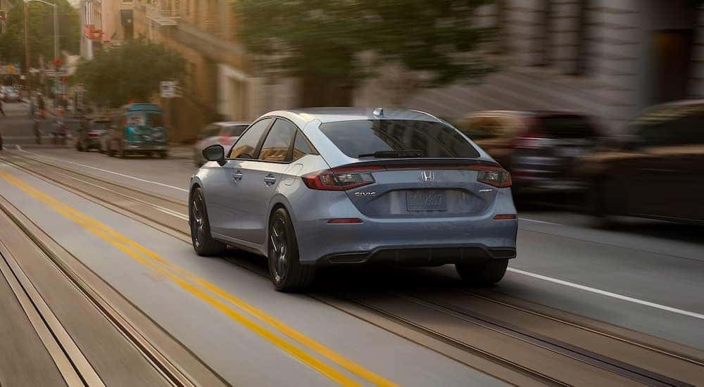 A grey 2022 Honda Civic is shown from the rear on a city street.