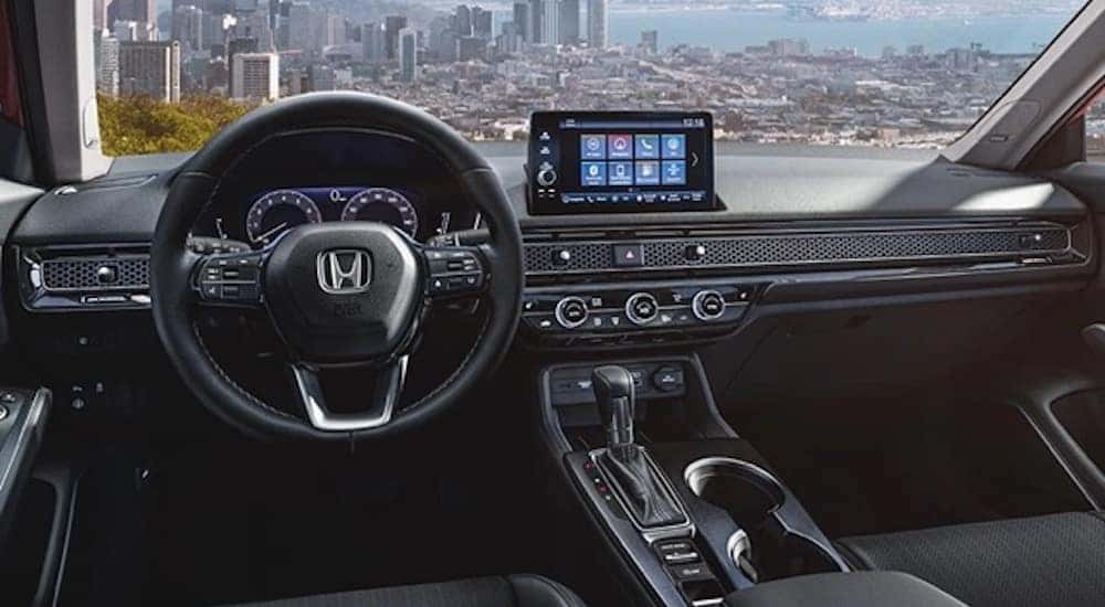 The black interior of a 2022 Honda Civic is shown from the driver's seat.