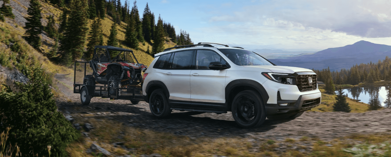 2024 Honda Passport towing an ATV in an off-road setting