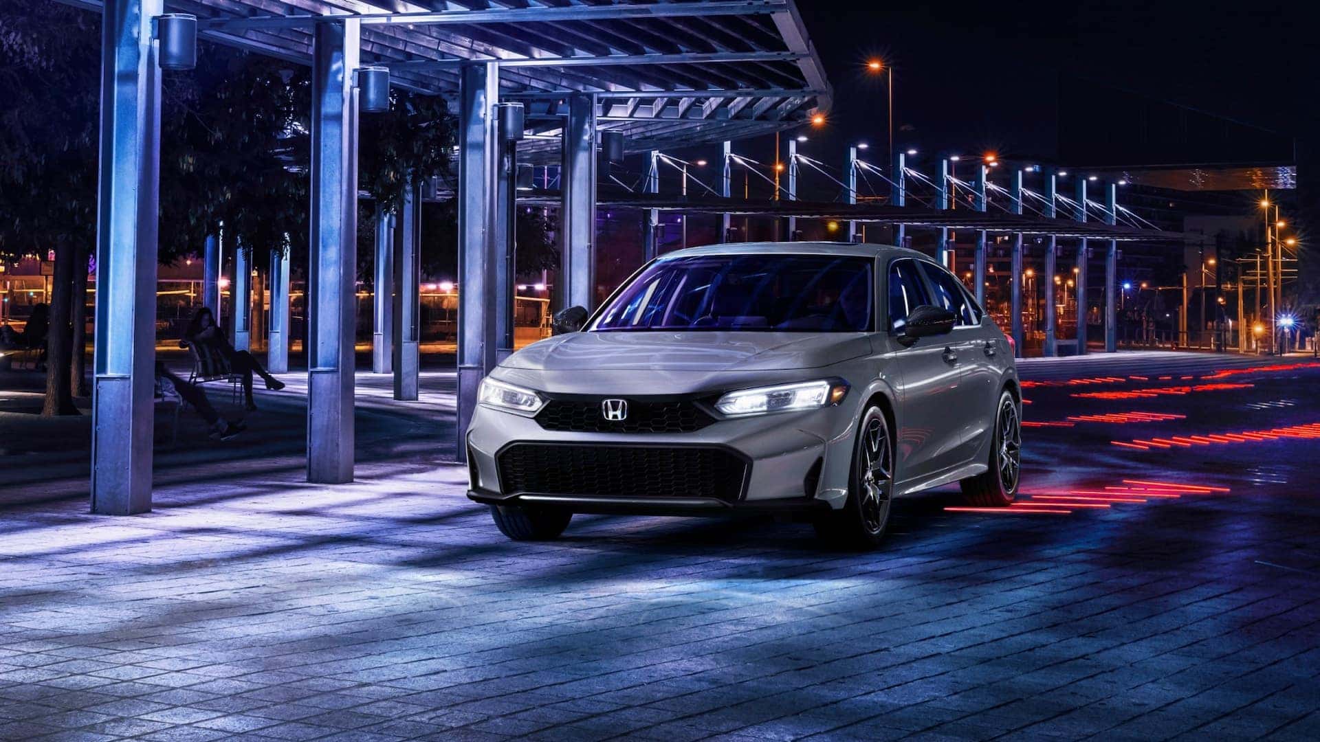 A silver Honda Civic Hybrid parked at night