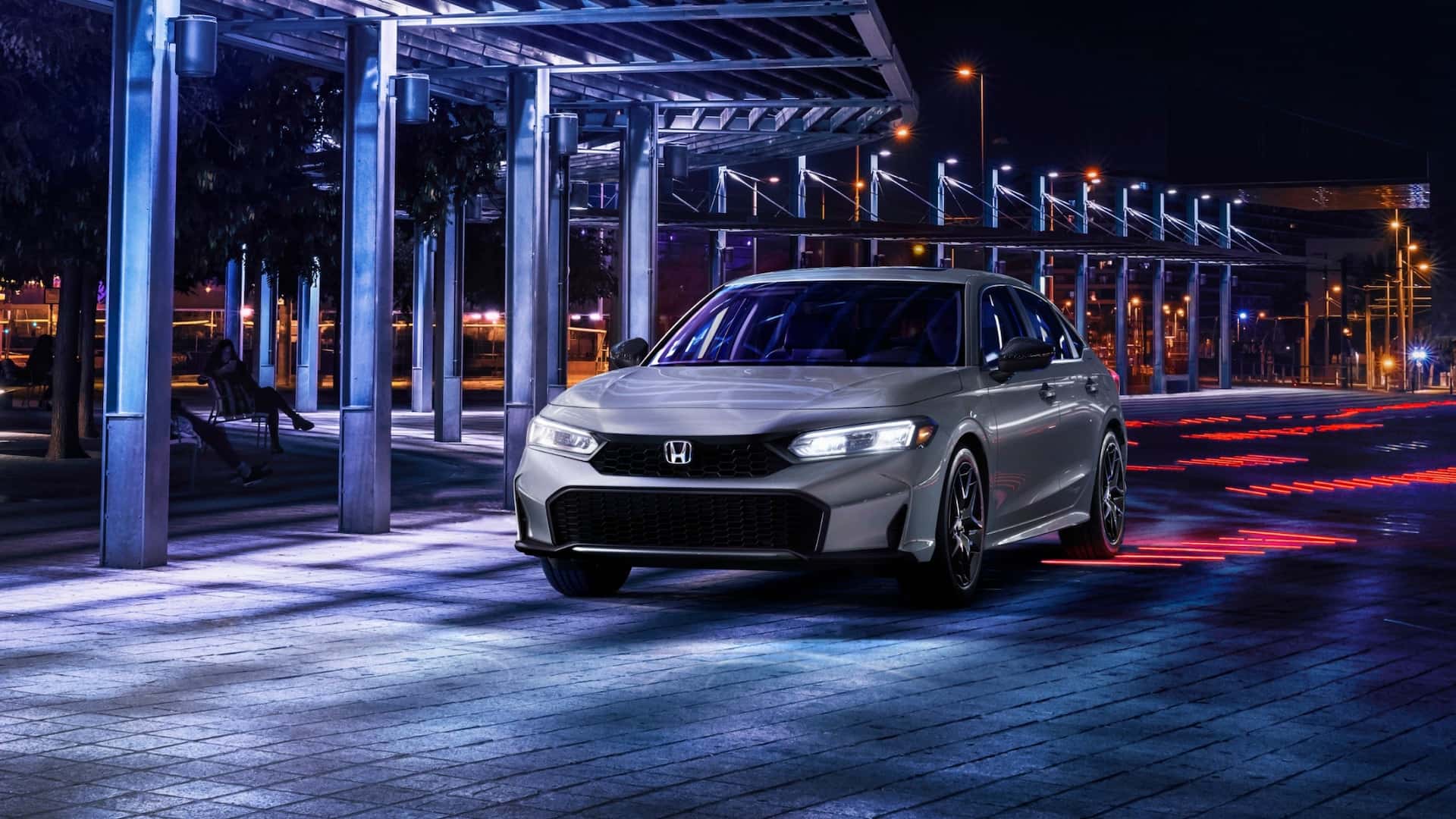 A gray Honda Civic parked at night