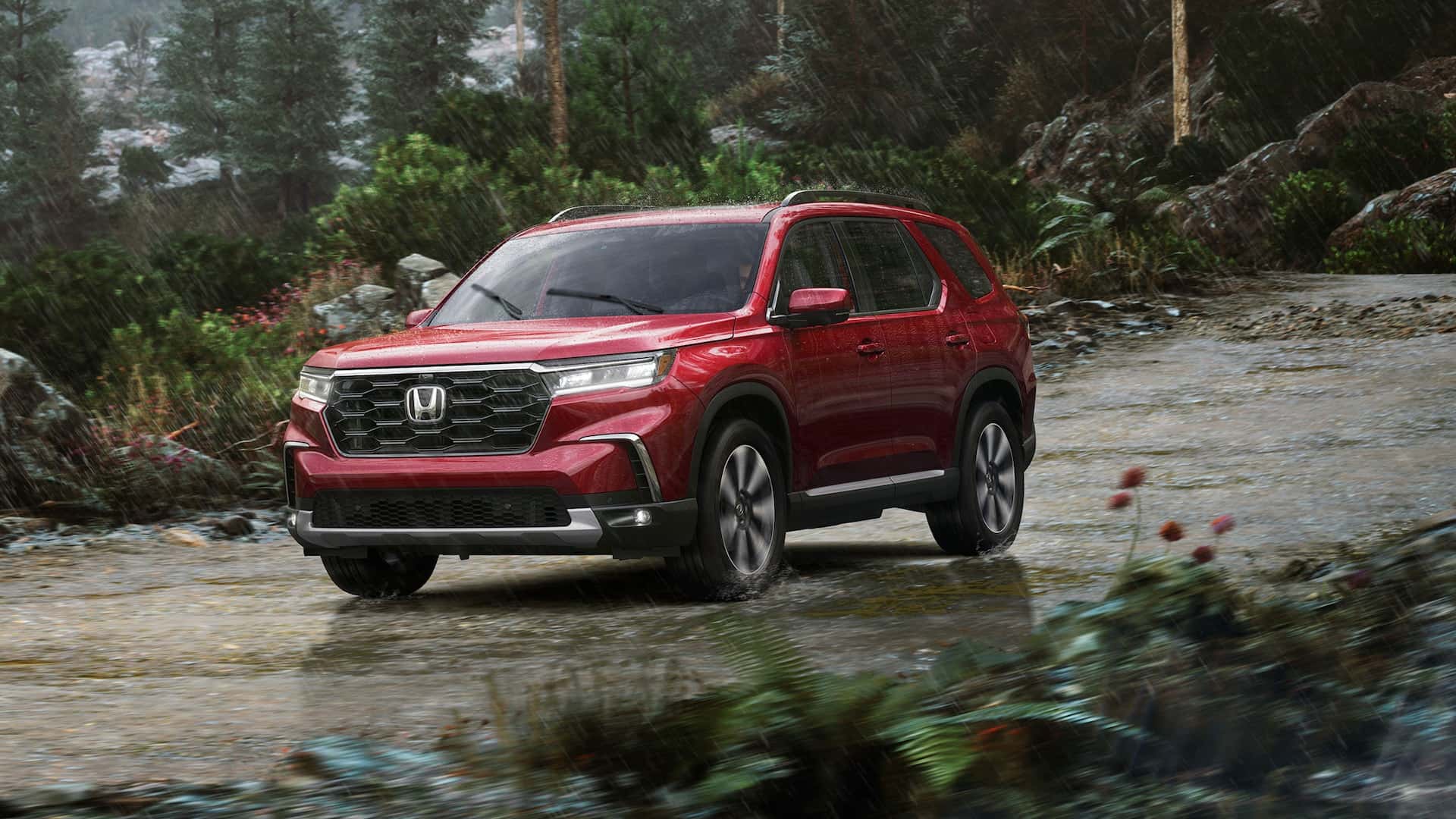 A red 2025 Honda Pilot driving down a flooded path