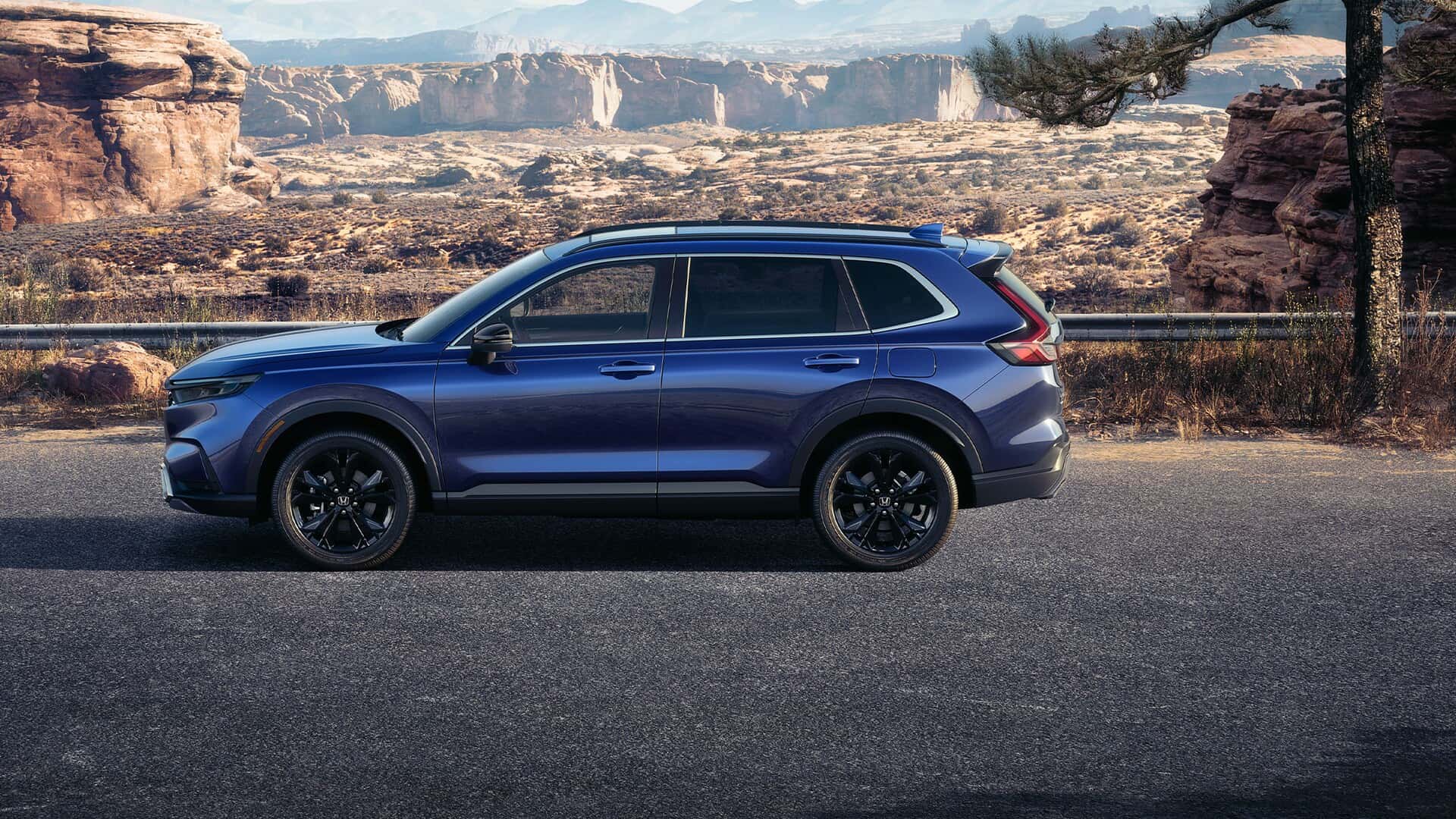 A blue Honda CR-V parked on the side of a road in a desert