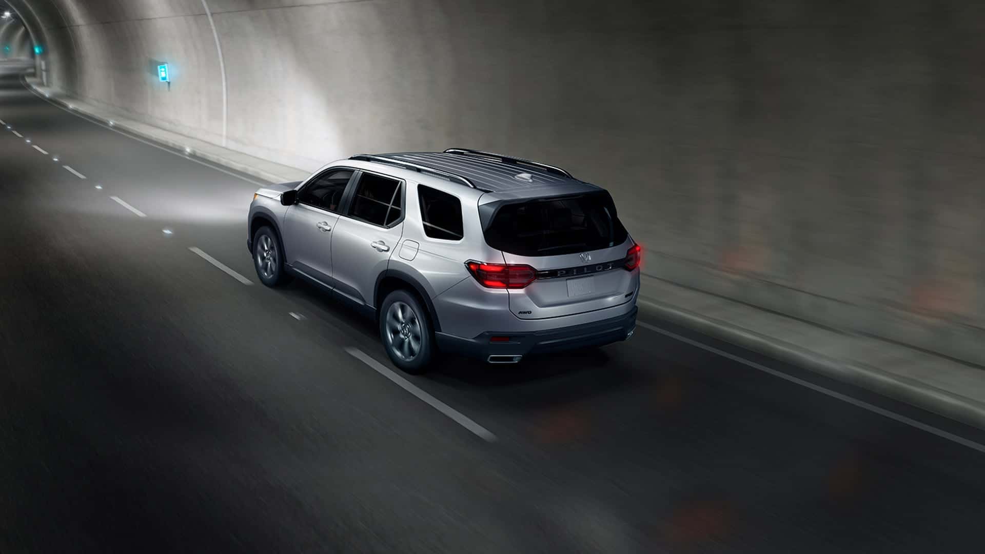 A silver Honda Pilot driving through a tunnel